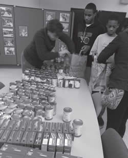 SDC staff and youth assemble Thanksgiving food baskets of donated food for client families.