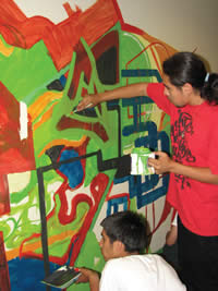 Young people participate in creating a mural as an art project with SDC’s Youth programs