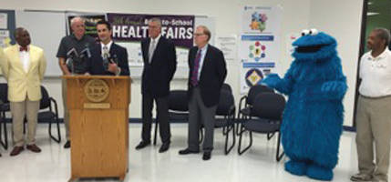 Health Commissioner Bevon Baker, Mayor Tom Barrett, United Healthcare’s Ryan Heath, Molina Healthcare Dental Director John Busby, Molina Healthcare President Scott Johnson, Cookie Monster and Milwaukee Urban Leauge President and CEO Ralph Hollman during a press conference. (Photo by Dylan Deprey)