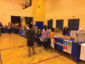 Families stroll over health related booths during the 16th Annual Back-to-School Fair. (Photo by Dylan Deprey)